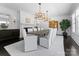 A view of the dining room, which boasts a large table, fireplace, and a stunning crystal chandelier at 2701 Sharon Rd, Charlotte, NC 28211