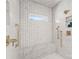 Luxurious shower with marble walls, rainfall shower head, and stylish gold fixtures at 2701 Sharon Rd, Charlotte, NC 28211