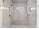 Spacious marble shower featuring dual shower heads, a bench, and a window at 2701 Sharon Rd, Charlotte, NC 28211