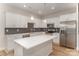Modern kitchen featuring stainless steel appliances, white cabinetry, a center island, and a gray hexagon backsplash at 2816 Old Steele Creek Rd, Charlotte, NC 28208