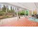 Covered porch with stone patio, outdoor seating, and landscaped backyard with mature trees at 329 N Oakwood Dr, Statesville, NC 28677