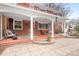 Red brick house featuring a covered porch with outdoor seating, stone patio and landscaped yard at 329 N Oakwood Dr, Statesville, NC 28677