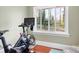 Bright exercise room with Peloton bike and natural light from the large window overlooking trees at 329 N Oakwood Dr, Statesville, NC 28677