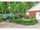 Landscaped exterior with brick and siding, featuring hydrangea bushes, a Japanese maple, and verdant greenery at 329 N Oakwood Dr, Statesville, NC 28677