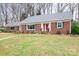Charming brick home with manicured lawn, mature trees, and a welcoming front entrance at 329 N Oakwood Dr, Statesville, NC 28677