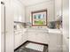 Classic kitchen featuring white cabinets, ample counter space, and a window with a wooded view at 329 N Oakwood Dr, Statesville, NC 28677