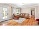 Cozy living room with hardwood floors, a classic leather sofa, and a rocking chair by the window at 329 N Oakwood Dr, Statesville, NC 28677