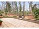 Stone patio with a built-in fire pit surrounded by a landscaped backyard at 329 N Oakwood Dr, Statesville, NC 28677