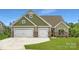 Charming home featuring a three-car garage, stone accents, and a well-manicured lawn at 4134 Camden Glen Rd, Lancaster, SC 29720
