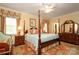 Spacious main bedroom boasts a four-poster bed, sitting area, and a large window with custom drapes at 419 Park Ridge Rd, Albemarle, NC 28001
