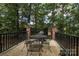 Back patio featuring outdoor table, chairs, and a grill. The patio is surrounded by brick columns and black metal railing at 419 Park Ridge Rd, Albemarle, NC 28001