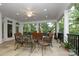 Covered patio with ceiling fan, outdoor furniture, and serene views of the surrounding trees and backyard at 419 Park Ridge Rd, Albemarle, NC 28001