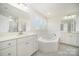 Bright bathroom with a large soaking tub, double vanity, and plenty of counter space at 4604 Howie Ln, Harrisburg, NC 28075