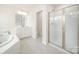 Modern bathroom featuring a large soaking tub and a frameless glass-enclosed shower at 4604 Howie Ln, Harrisburg, NC 28075
