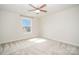 Bright, empty bedroom with plush carpeting and a window overlooking a neighboring home at 4604 Howie Ln, Harrisburg, NC 28075