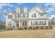 Charming two-story home featuring white siding, dormer windows, stone accents, and a well-manicured front lawn at 4604 Howie Ln, Harrisburg, NC 28075