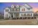 Gorgeous two-story home with a porch, manicured lawn, and charming curb appeal at 4604 Howie Ln, Harrisburg, NC 28075
