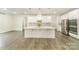 Bright kitchen with large island, stainless steel appliances, white cabinetry, and wood floors at 4604 Howie Ln, Harrisburg, NC 28075
