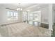Open-concept living area featuring carpet and wood flooring, with views of the entryway and abundant natural light at 4604 Howie Ln, Harrisburg, NC 28075