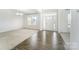 Bright living room featuring wood and carpet flooring, complemented by a white front door at 4604 Howie Ln, Harrisburg, NC 28075
