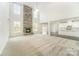Spacious living room with a stone fireplace, large windows, and an open view to the kitchen area at 4604 Howie Ln, Harrisburg, NC 28075
