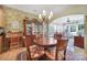 Dining area with a round wooden table and chairs, a chandelier, and access to a china cabinet at 52194 Longspur Ln, Fort Mill, SC 29707