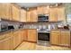 Kitchen featuring wooden cabinetry, tile backsplash, and stainless steel appliances including a oven and microwave at 52194 Longspur Ln, Fort Mill, SC 29707