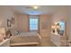 Cozy bedroom with a comfortable bed, dresser, bedside tables, lamp and a window at 5235 Reedy Ridge Rd, Charlotte, NC 28215