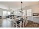 Open concept dining area with a dark table, white chairs, modern lighting, and view to the living room at 646 Kahana River Rd, Fort Mill, SC 29715