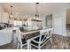 Dining area featuring a dark wood table with white chairs and bench, open to the kitchen and living areas at 646 Kahana River Rd, Fort Mill, SC 29715