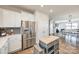 Open concept kitchen with stainless steel refrigerator, white cabinets, a center island, and hardwood floors at 646 Kahana River Rd, Fort Mill, SC 29715