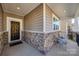 Inviting front porch with stone accents, seating, and a stylish front door with a decorative wreath at 646 Kahana River Rd, Fort Mill, SC 29715
