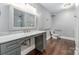 Modern bathroom featuring a marble countertop, grey cabinets, and wood-look floors at 8105 Dumphries Dr, Huntersville, NC 28078