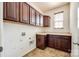 Laundry room features brown cabinets, neutral countertops, and tile floor at 8315 Bridgegate Dr, Huntersville, NC 28078