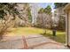 This backyard features a patio and a large grassy area with plenty of trees at 9138 Babbitt Way, Charlotte, NC 28216