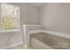Bathroom featuring a large soaking tub and a window to provide natural lighting at 9138 Babbitt Way, Charlotte, NC 28216
