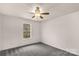 Cozy bedroom features soft carpet, a ceiling fan, and a bright window at 9138 Babbitt Way, Charlotte, NC 28216