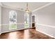 Dining room with hardwood floors, neutral paint, decorative wainscoting, and large windows for natural light at 9138 Babbitt Way, Charlotte, NC 28216