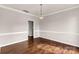 Dining room with hardwood floors, neutral paint, decorative wainscoting, and an ornate hanging light fixture at 9138 Babbitt Way, Charlotte, NC 28216
