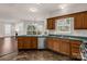 Kitchen with wood cabinets, stainless steel appliances, with an open view to the living room and backyard at 9138 Babbitt Way, Charlotte, NC 28216