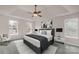 Stylishly furnished main bedroom featuring a ceiling fan, tray ceilings, three large windows, and a comfortable bed at 9138 Babbitt Way, Charlotte, NC 28216