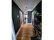 Hallway painted with dark colors with hardwood floors and two shelved sides at 101 Sunset Dr, Stanley, NC 28164