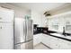 Cozy kitchen with black countertops, white cabinets and stainless steel refrigerator at 101 Sunset Dr, Stanley, NC 28164