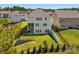 Backyard with a lush green lawn, black fence, tiered retaining wall, and covered patio extending from the house at 1017 Cheviot Ct, Waxhaw, NC 28173