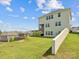 Expansive backyard with lush green lawn, tiered retaining wall, black fence, and a covered patio on the house at 1017 Cheviot Ct, Waxhaw, NC 28173