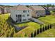 The backyard features a lush green lawn, black fence, tiered retaining wall, and a covered patio on the house at 1017 Cheviot Ct, Waxhaw, NC 28173