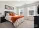 Comfortable bedroom featuring a large window and a plush bed with orange accents at 1017 Cheviot Ct, Waxhaw, NC 28173