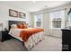 Comfortable bedroom featuring a large window and a plush bed with orange accents at 1017 Cheviot Ct, Waxhaw, NC 28173