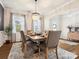 Elegant dining room with a chandelier, large windows, and a table set for a formal meal at 1017 Cheviot Ct, Waxhaw, NC 28173