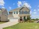 Charming two-story home with a well-manicured lawn and attached two-car garage on a sunny day at 1017 Cheviot Ct, Waxhaw, NC 28173